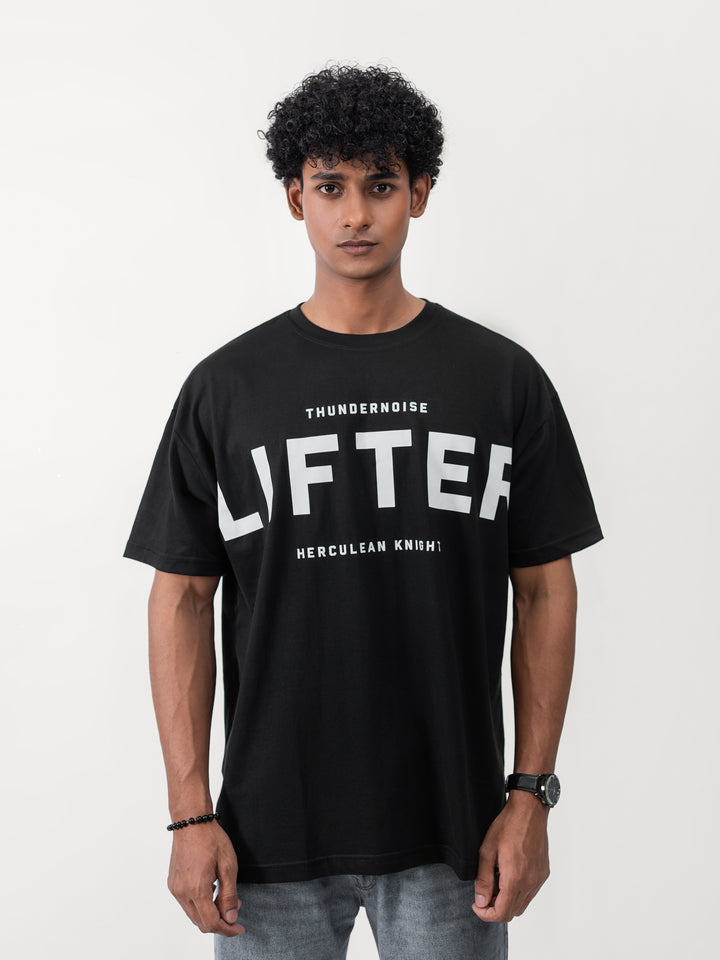 Model wearing black Galactic Knight drop shoulder tee by Herculean Knight, 100% cotton, size XL, streetwear + gym fusion