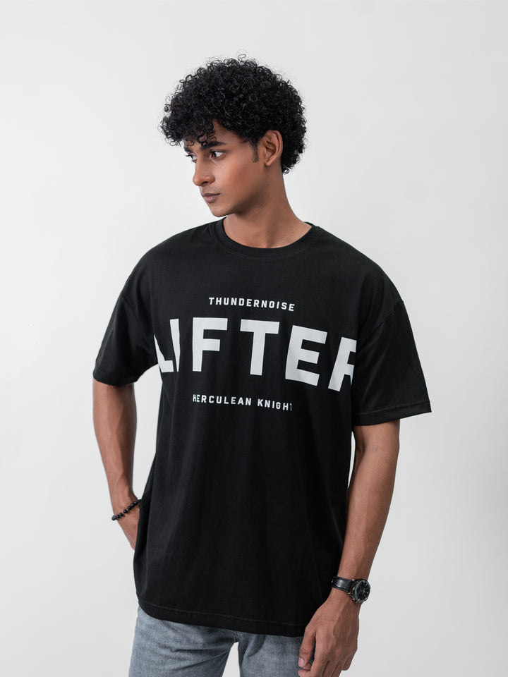 Model wearing black Galactic Knight drop shoulder tee by Herculean Knight, 100% cotton, size XL, streetwear + gym fusion