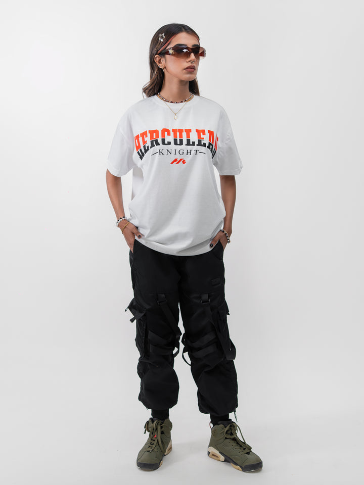 Woman 5ft2 in XS Herculean Knight white oversized drop-shoulder gym tee with orange graphic