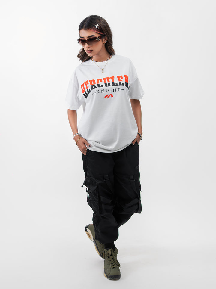 Woman 5ft2 in XL Herculean Knight white oversized drop-shoulder gym tee with orange graphic