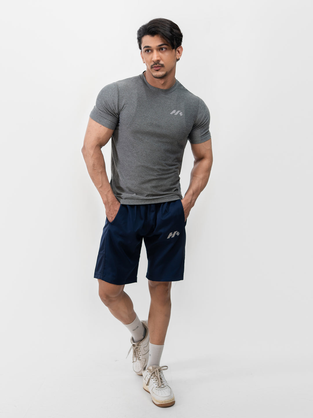 Male athlete 5 ft 8 in wearing size S Herculean Metal Grey Dri-Blend Training Tee, hands on hips, front view against white background.