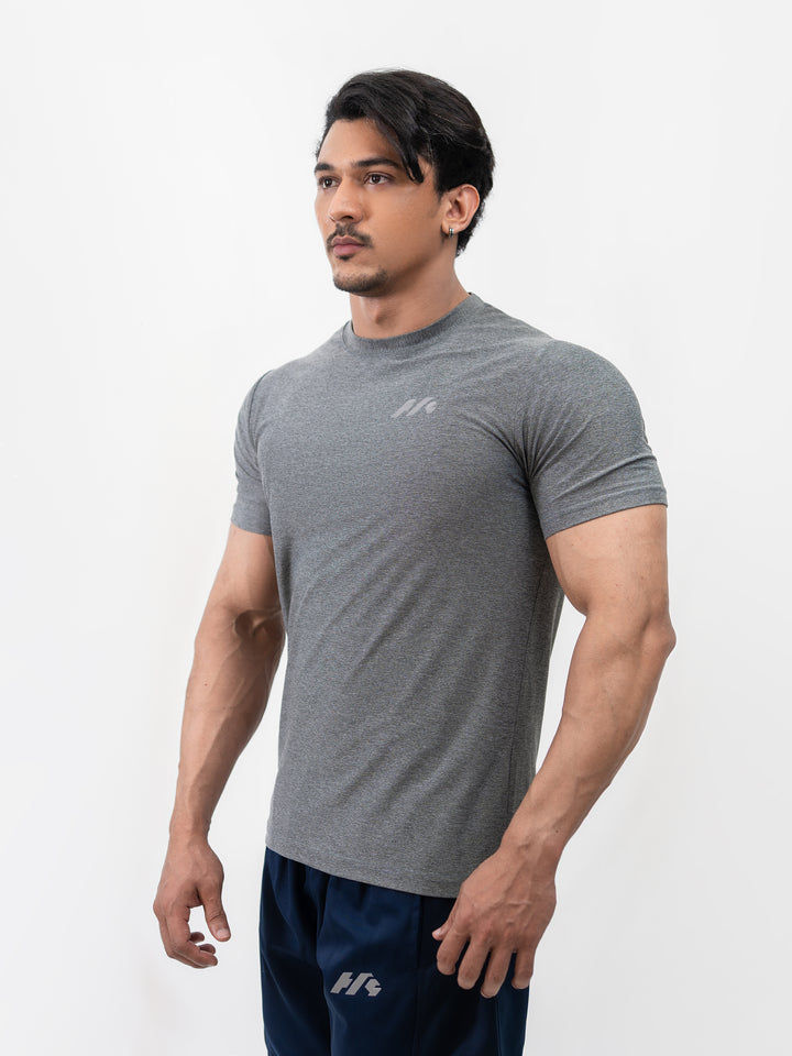 Male athlete 5 ft 8 in wearing size S Herculean Metal Grey Dri-Blend Training Tee, hands on hips, front view against white background.