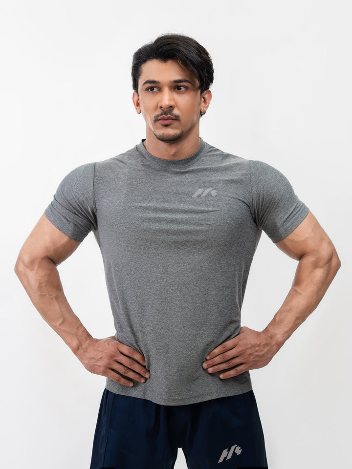 Male athlete 5 ft 8 in wearing size S Herculean Metal Grey Dri-Blend Training Tee, hands on hips, front view against white background.