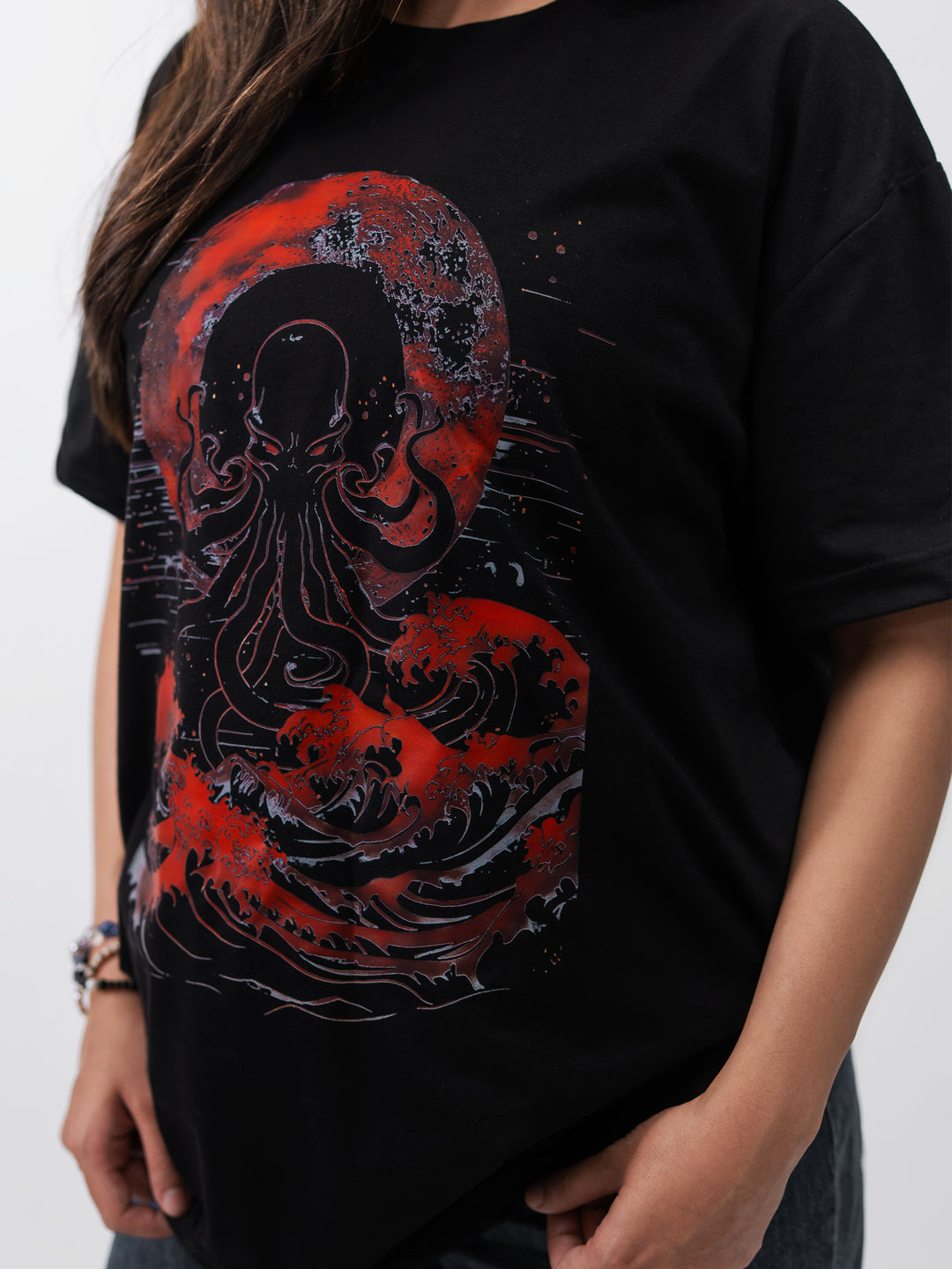Woman wearing black oversized Kraken graphic drop-shoulder T-shirt by Herculean Knight, front view.