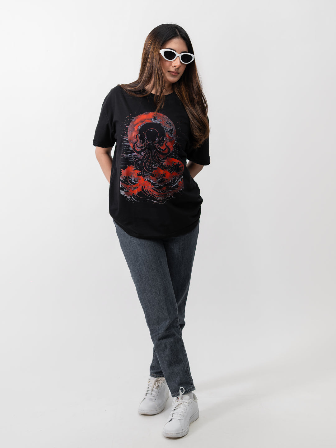 Woman wearing black oversized Kraken graphic drop-shoulder T-shirt by Herculean Knight, front view.
