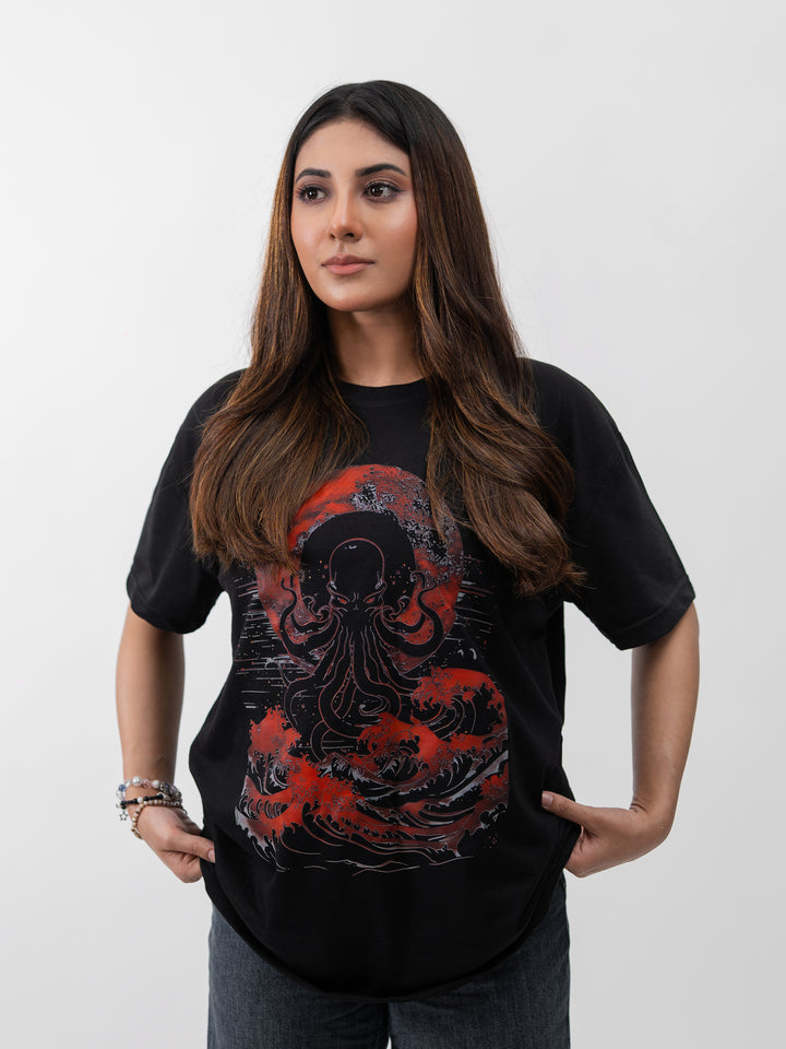 Woman wearing black oversized Kraken graphic drop-shoulder T-shirt by Herculean Knight, front view.